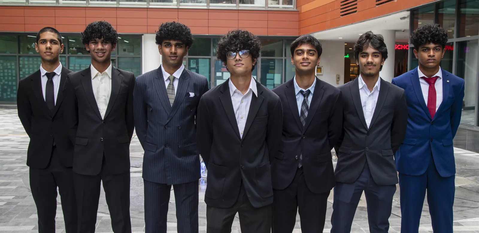 The FIRE team — seven students in formal wear standing together on campus