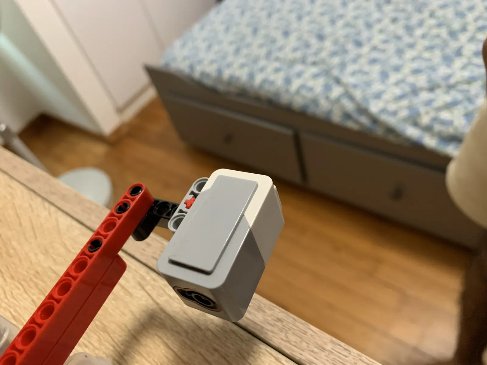 LEGO EV3 sensor module on a red Technic arm — part of LYRA's gesture-driven robot-arm bridge